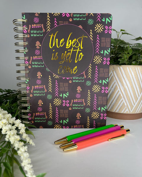 Black spiral bound notebook with trendy African American girl patterned cover and 3 colorful ballpoint pens